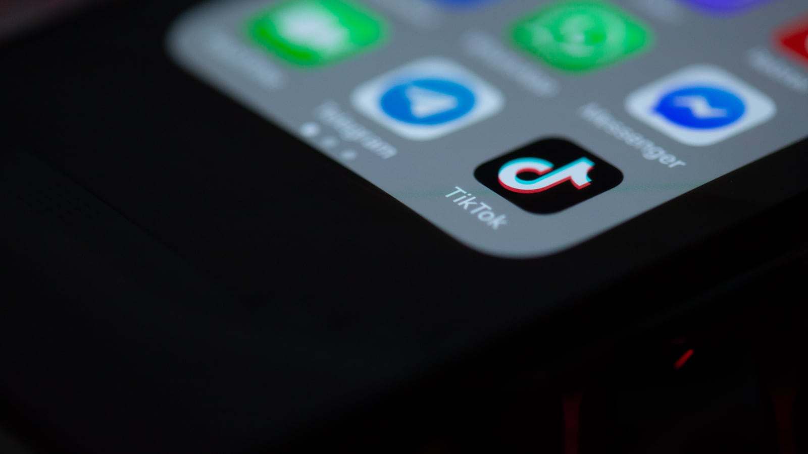 Close-up of the TikTok app icon on a smartphone home screen, next to the Telegram and Messenger icons.